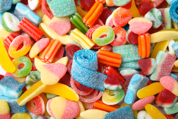 Tasty colorful jelly candies as background, above view